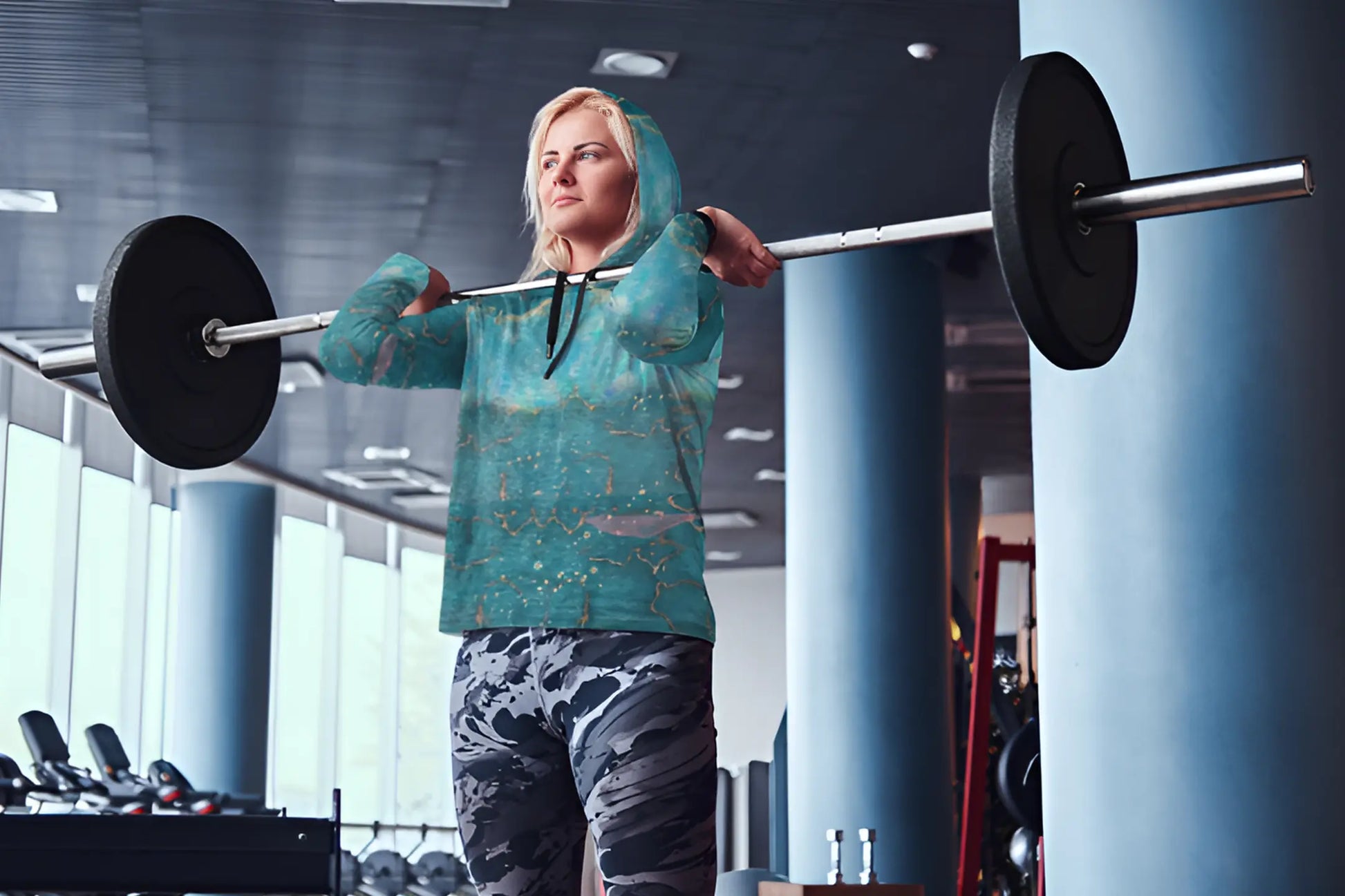 a woman lifting a barbell in a gym